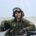 Your fighter jet pilot in his unform posing for photograph.