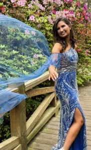 IOPSC high school graduate, Ava Zimov, modeling a dress on a scenic walkway.