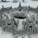 An intricate castle made with sand, in the form of a drip castle.
