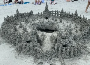 An intricate castle made with sand, in the form of a drip castle.