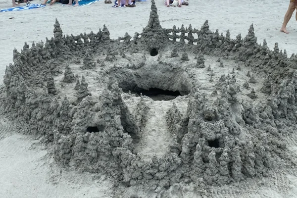 An intricate castle made with sand, in the form of a drip castle.