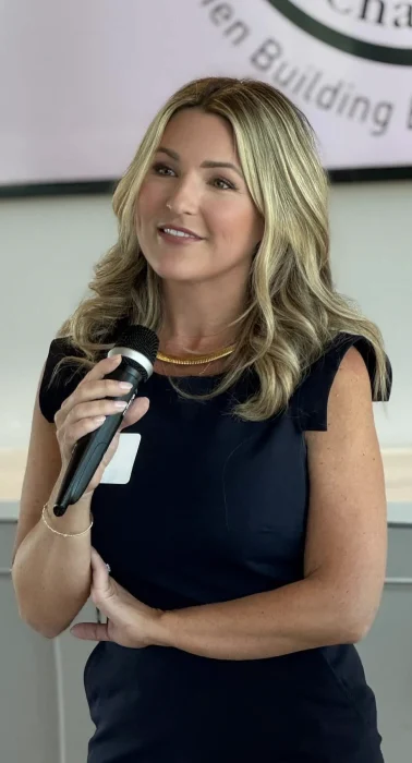 Former CIA agent and author, Brittany Butler, holding a microphone as she speaks to an audience of her readers.