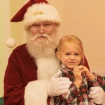 A picture of a young girl sitting on Santa's lap, on IOP, SC.