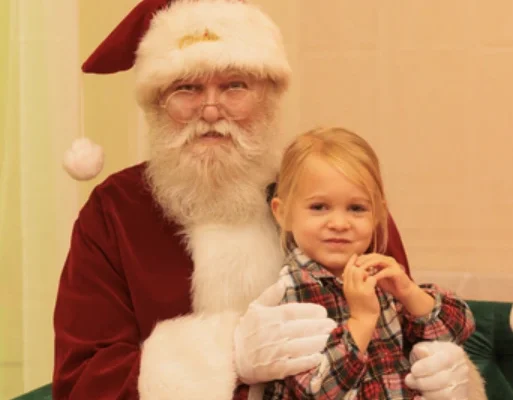 A picture of a young girl sitting on Santa's lap, on IOP, SC.