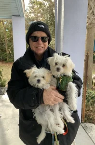 The father of the Woods family cradling their two dogs, Jojo and Rosie.