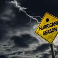 A Fictional "Hurricane Season" road sign with a stormy, dark sky in the background