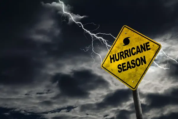 A Fictional "Hurricane Season" road sign with a stormy, dark sky in the background