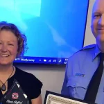 Retiring IOPFD Fire Chief Travis Stafford holding awards with wife Kelly by his side