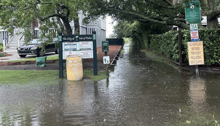 A picture of an outdoor walkway that is flooded by excess water, caused by Tropical Storm Debby.