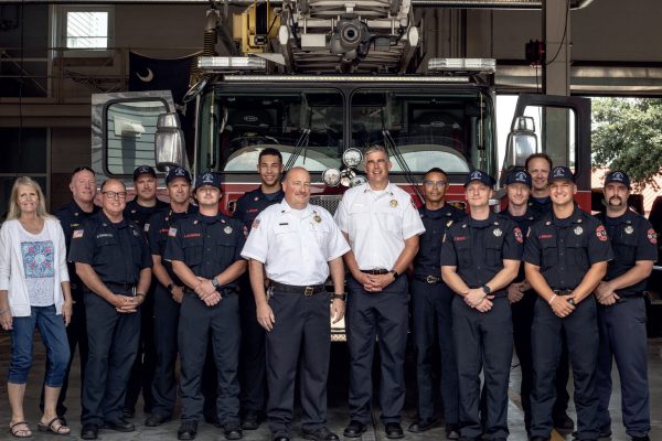 A picture looking into the Isle of Palms fire-station showcasing the IOP Firefighters lined up for a group photo in front of one of their firetrucks.