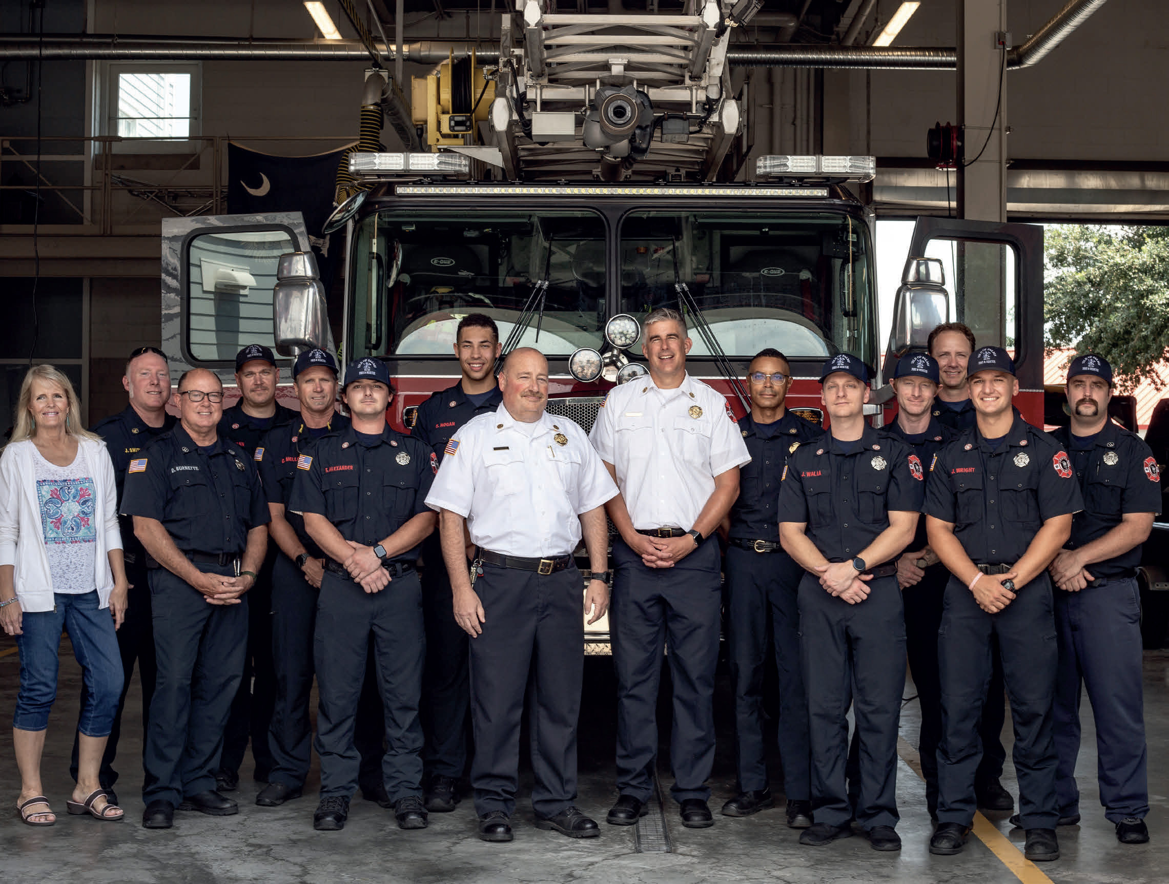 A picture looking into the Isle of Palms fire-station showcasing the IOP Firefighters lined up for a group photo in front of one of their firetrucks.